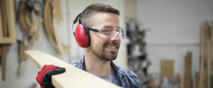 man working with wood wearing ear and eye protection